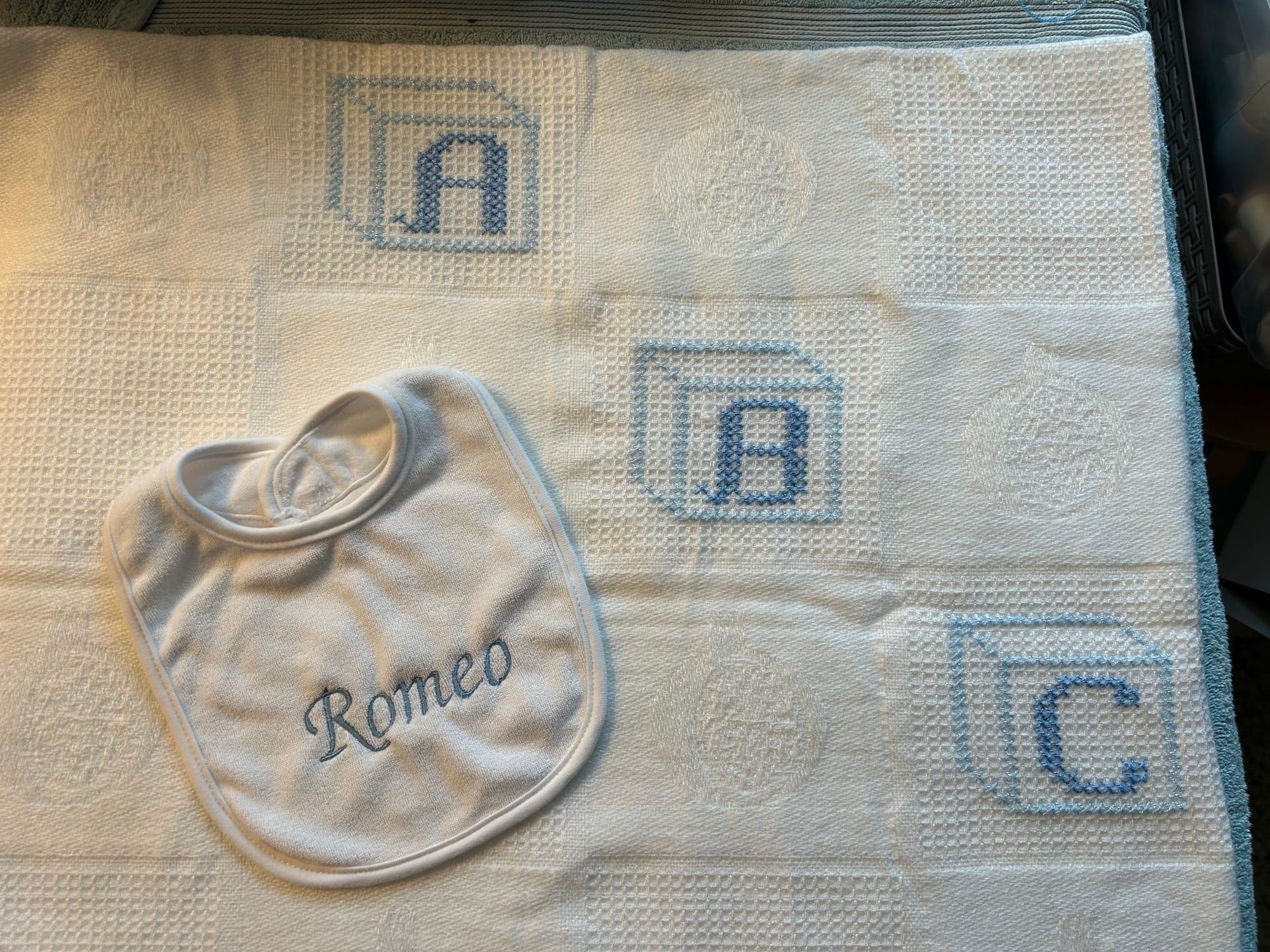 Romeo bib with matching blue alphabet blanket
