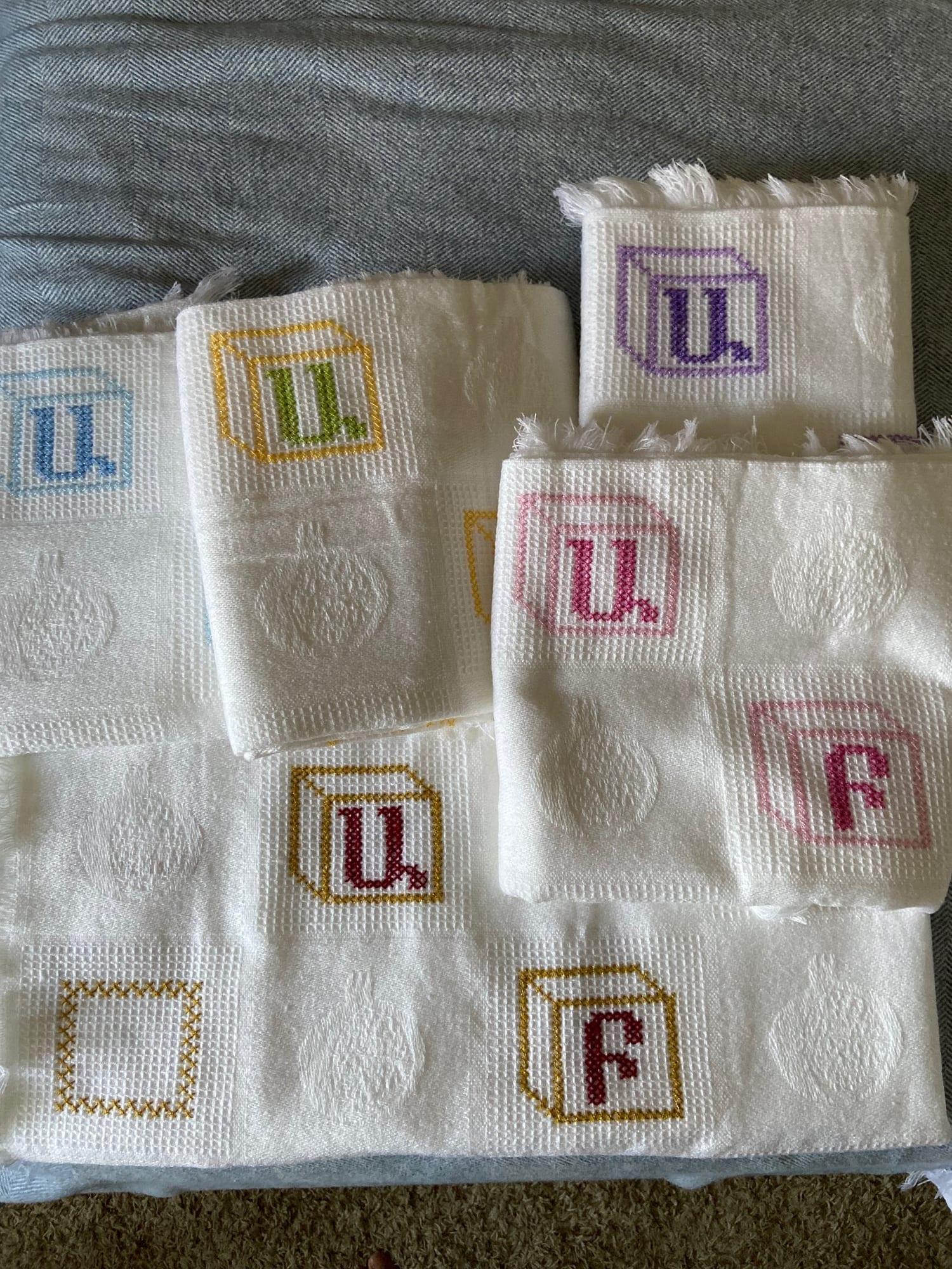 Stack of machine-embroidered bibs in different colors