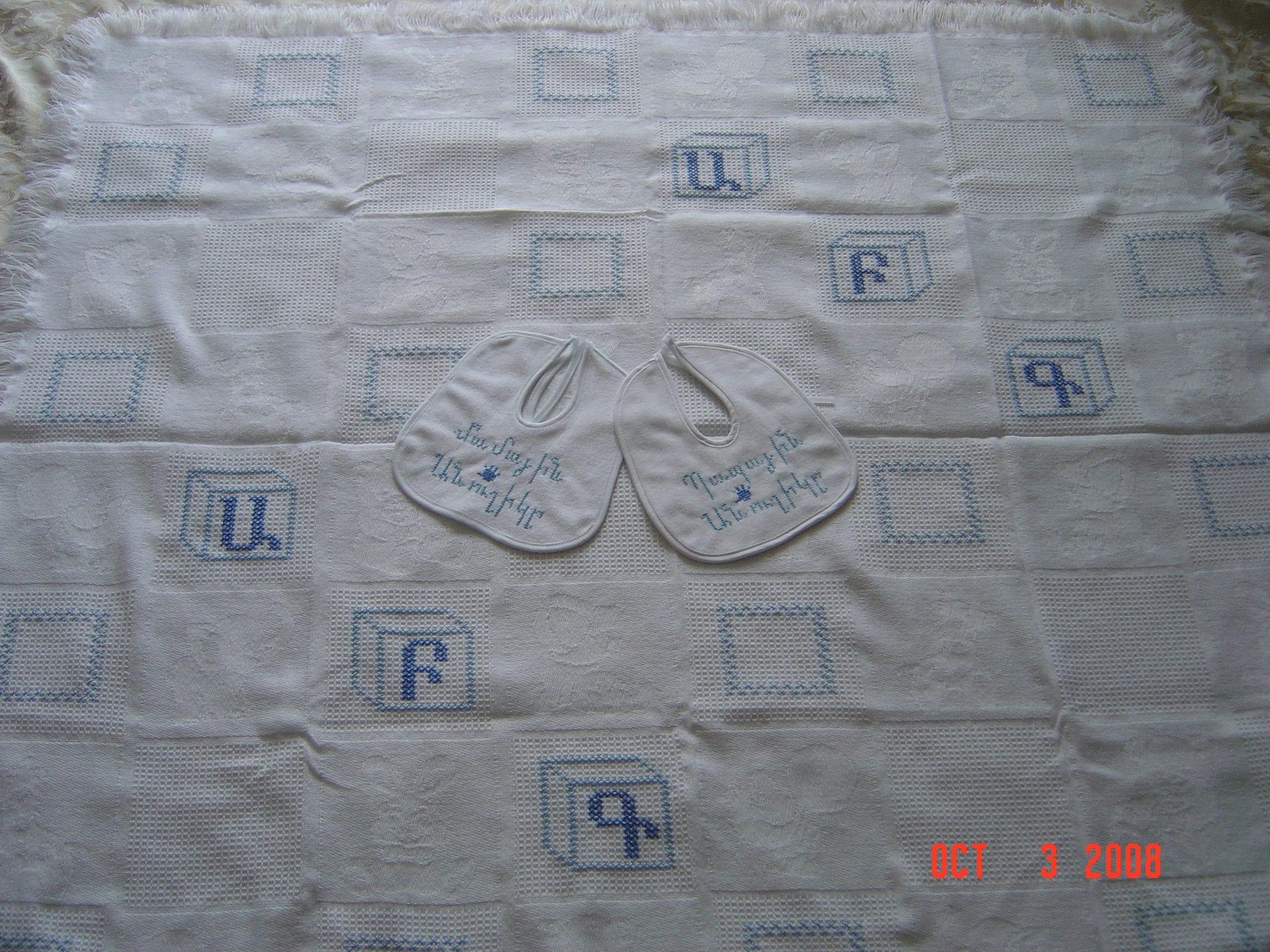 Matching cross-stitched blanket and bib set by Lusik